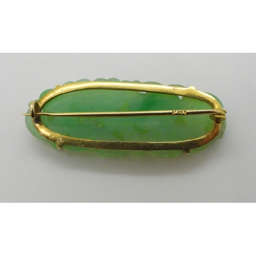 2784 - A CHINESE GREEN HARDSTONE BROOCHmounted in 18k gold, and carved with fruit and flowers. dimensions 3... 