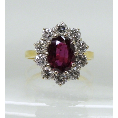 2786 - A RUBY AND DIAMOND CLUSTER RINGmounted in a classic 18ct gold basket mount, set with a oval cut ruby... 