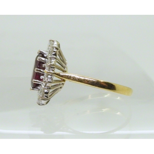 2786 - A RUBY AND DIAMOND CLUSTER RINGmounted in a classic 18ct gold basket mount, set with a oval cut ruby... 