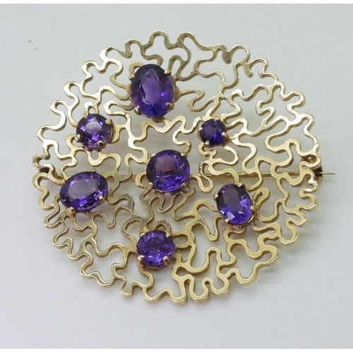 2796 - A RETRO AMETHYST BROOCHthe wriggle work design is set with round and oval mixed cut amethysts. Made ... 