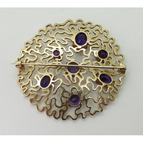 2796 - A RETRO AMETHYST BROOCHthe wriggle work design is set with round and oval mixed cut amethysts. Made ... 