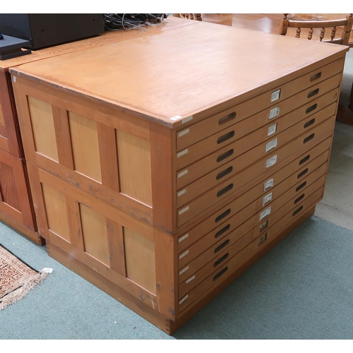 41 - A 20th century pine plan chest with ten shallow drawers flanked by panelled sides, 92cm high x 122cm... 