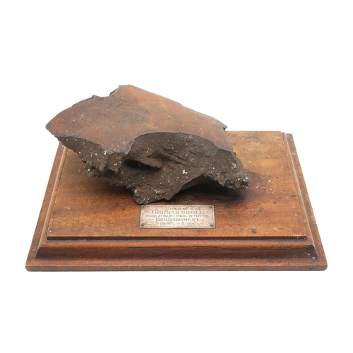 347 - A heavy shrapnel fragment set upon a plinth base with plaque affixed reading 