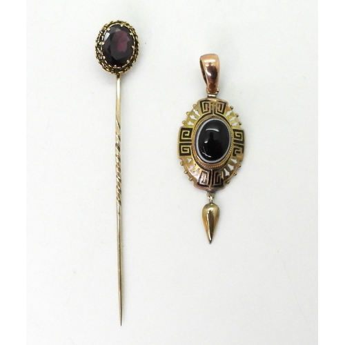 700 - A Victorian yellow metal pendant set with a Bull's eye agate, with black and white Greek key and bud... 