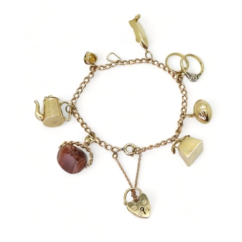 776 - A 9ct gold charm bracelet with seven attached 9ct gold and yellow metal charms to include a speed bo... 