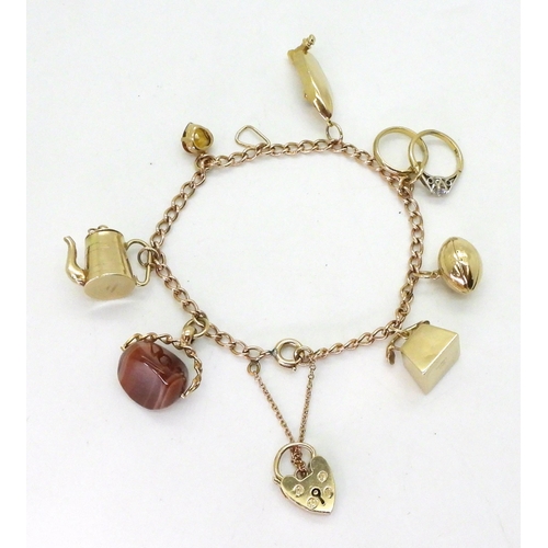 776 - A 9ct gold charm bracelet with seven attached 9ct gold and yellow metal charms to include a speed bo... 