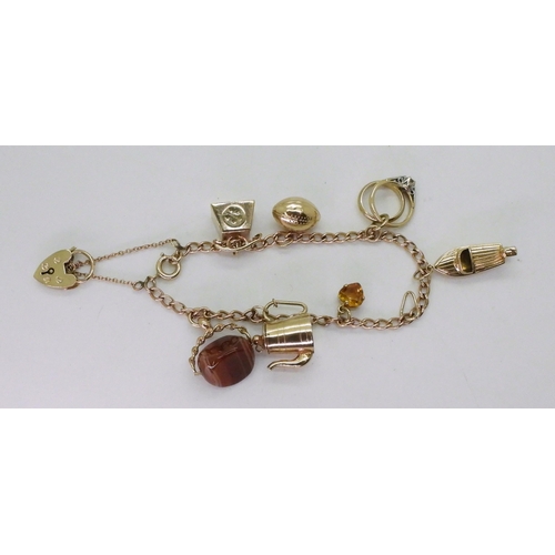 776 - A 9ct gold charm bracelet with seven attached 9ct gold and yellow metal charms to include a speed bo... 