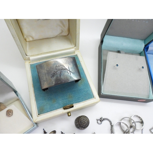 793 - A silver napkin ring engraved with a mouse, a Caithness glass silver cross, a heavy silver curb chai... 