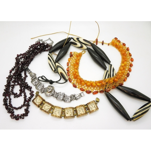 818 - A multi strand garnet necklace, a carved antler bracelet, a white metal Egyptian themed bracelet and... 