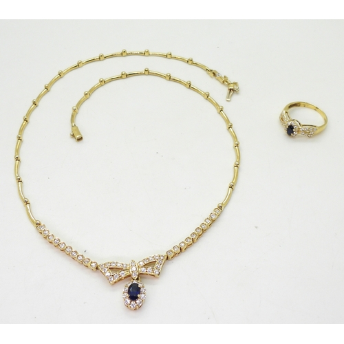 2801 - AN ARABIC GOLD NECKLACE AND RINGset with blue and clear gems to the bow motif, length of necklace ap... 