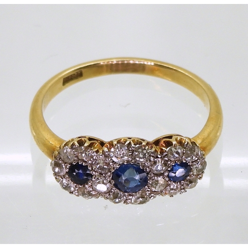 2827 - A THREE FLOWER CLUSTER RINGset with three round cut sapphires surrounded with old cut diamonds with ... 