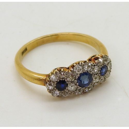 2827 - A THREE FLOWER CLUSTER RINGset with three round cut sapphires surrounded with old cut diamonds with ... 