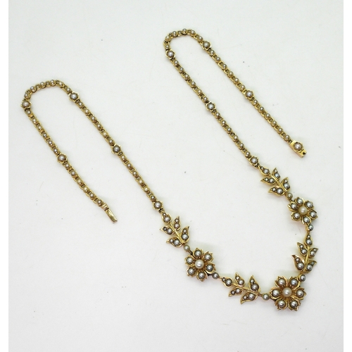 2830 - AN EDWARDIAN SPLIT PEARL FLOWER NECKLACEthe bright yellow metal necklace is set throughout in split ... 