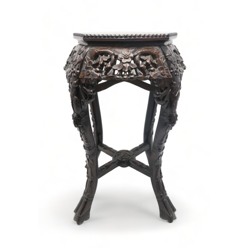 2395 - A CHINESE CARVED HARDWOOD MARBLE STANDthe circular top above four openwork foliate carved aprons, wi... 