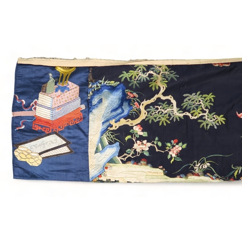 2397 - A CHINESE BLUE GROUND SILK EMBROIDERED PANELdepicting cranes and deer amongst peaches, pine trees, p... 