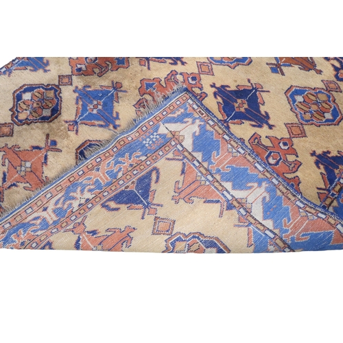 2140 - A LARGE BEIGE GROUND MALAYER RUNNER with multicoloured medallions and geometric borders, 647cm ... 