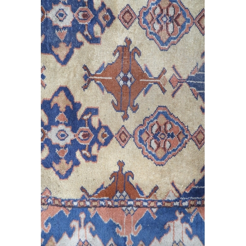 2140 - A LARGE BEIGE GROUND MALAYER RUNNER with multicoloured medallions and geometric borders, 647cm ... 