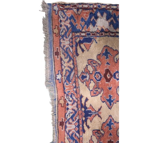 2140 - A LARGE BEIGE GROUND MALAYER RUNNER with multicoloured medallions and geometric borders, 647cm ... 