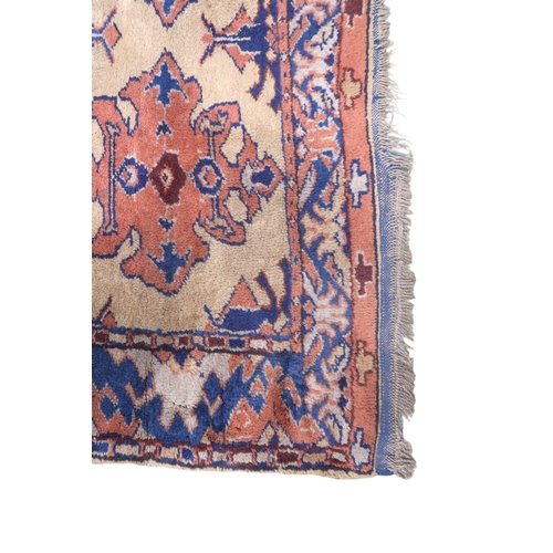 2140 - A LARGE BEIGE GROUND MALAYER RUNNER with multicoloured medallions and geometric borders, 647cm ... 