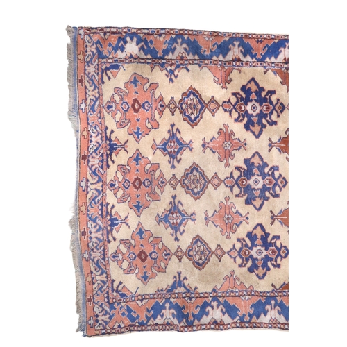 2140 - A LARGE BEIGE GROUND MALAYER RUNNER with multicoloured medallions and geometric borders, 647cm ... 