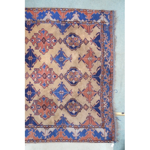 2140 - A LARGE BEIGE GROUND MALAYER RUNNER with multicoloured medallions and geometric borders, 647cm ... 