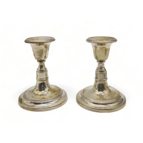 353 - A pair of silver dwarf candlesticks (weighted), by B & Co Ltd, Birmingham 1954, with concentric ... 