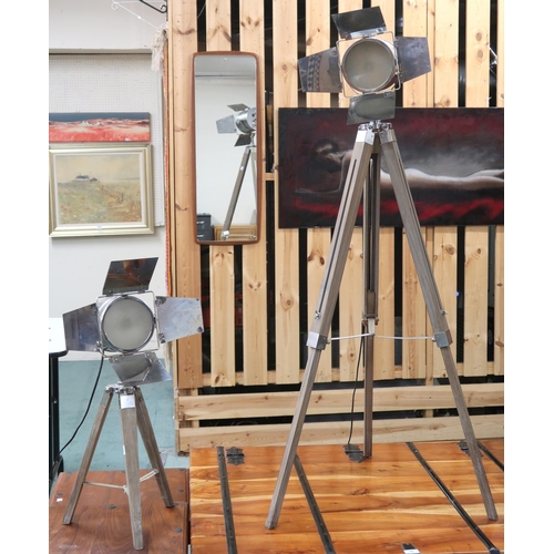 63 - A lot comprising two assorted reproduction film style spotlight lamps on folding tripod base the tal... 