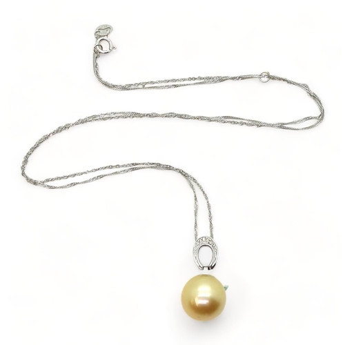 702 - An 18ct white gold golden South sea pearl pendant further set with diamond accents and on a 18ct whi... 