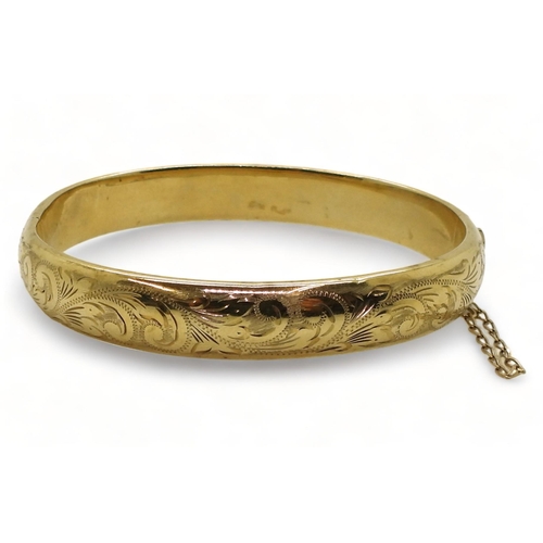 719 - A 9ct gold hand engraved hollow bangle, inner diameter 6cm, weight 12.1gms