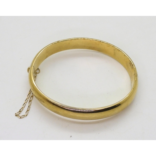 719 - A 9ct gold hand engraved hollow bangle, inner diameter 6cm, weight 12.1gms