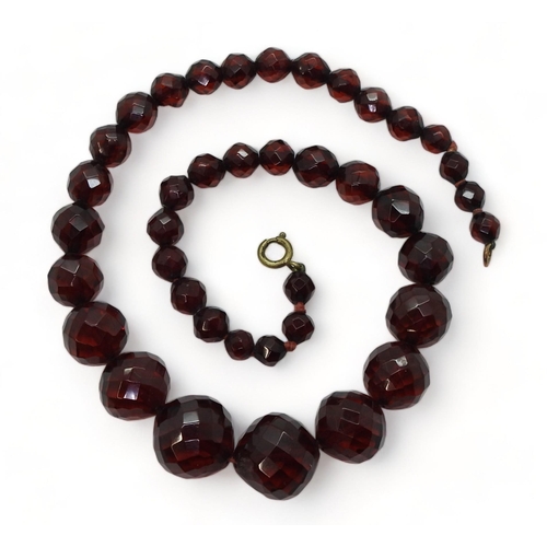 721 - A string of faceted cherry amber coloured beads, the largest is 18.5mm, and the smallest 7.3mm, tota... 