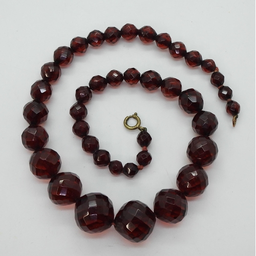 721 - A string of faceted cherry amber coloured beads, the largest is 18.5mm, and the smallest 7.3mm, tota... 