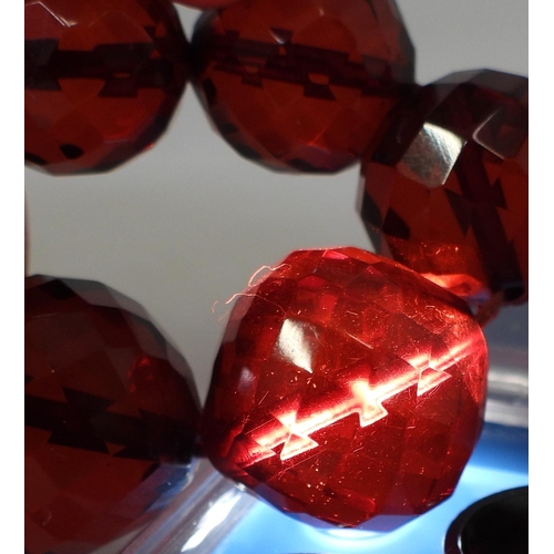 721 - A string of faceted cherry amber coloured beads, the largest is 18.5mm, and the smallest 7.3mm, tota... 