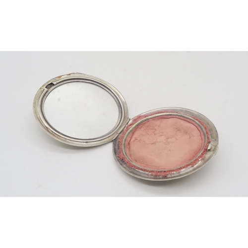 351 - A silver circular powder compact, by Gieves ltd, with engine-turned decoration and an applied crown ... 