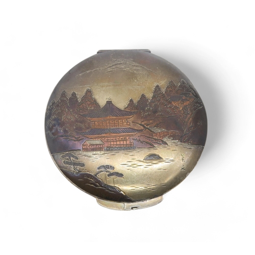 359 - A Japanese silver niello compact, the lid decorated with a landscape scene, 8cm diameter, 80gms