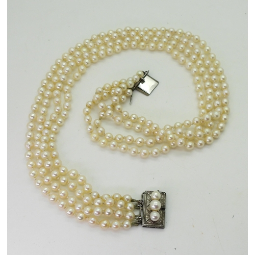 718 - A four strand cultured pearl necklace, with a silver and pearl clasp, length of shortest length 47cm... 