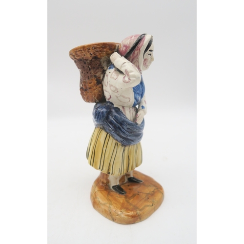 211 - A early 19th century Scottish East Coast pottery fishwife figure, modelled carrying a basket of fish