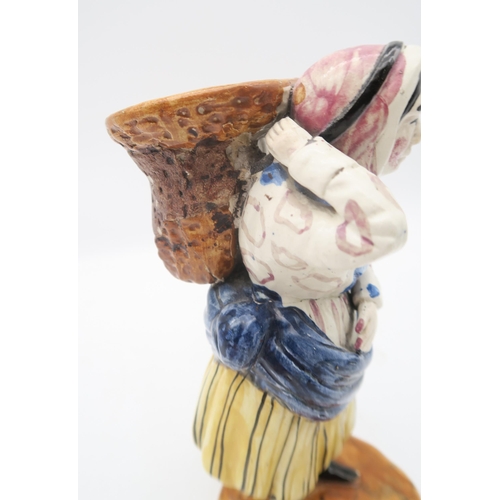 211 - A early 19th century Scottish East Coast pottery fishwife figure, modelled carrying a basket of fish