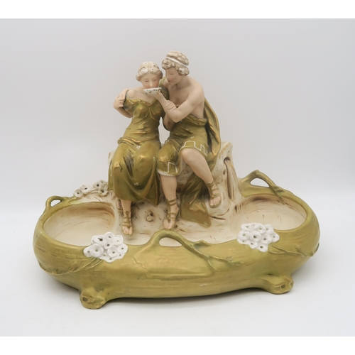 230 - A Royal Dux centrepiece modelled as a couple drinking from a bowl, together with a goat pulling a ca... 