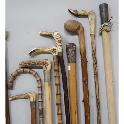 555 - A large collection of walking sticks and riding crops, to include an ebonised walking cane with Lond... 