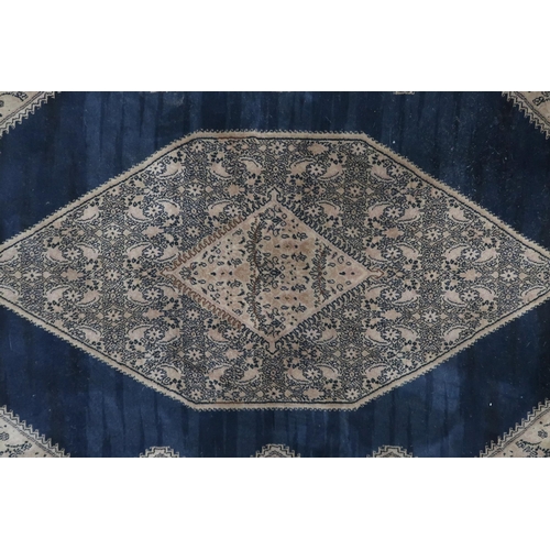 110 - A dark blue ground Sarouk rug with beige geometric central medallion, matching spandrels and geometr... 