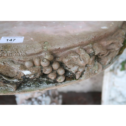 147 - A contemporary stoneware garden table with circular top decorated with fruit and foliate casting on ... 