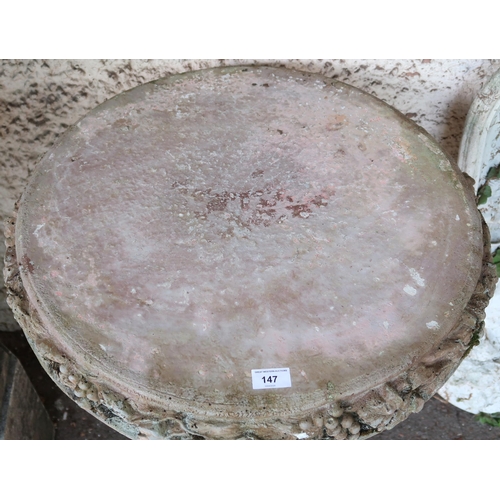 147 - A contemporary stoneware garden table with circular top decorated with fruit and foliate casting on ... 