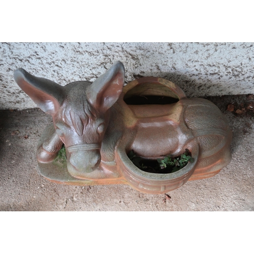 151 - A contemporary decorative stoneware garden planter modelled as a donkey at rest with saddlebags acti... 