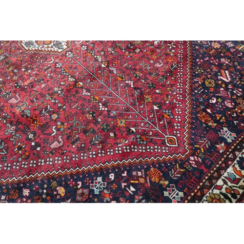36 - A red ground Qash'qai rug with cream geometric central medallion on geometric floral ground within d... 