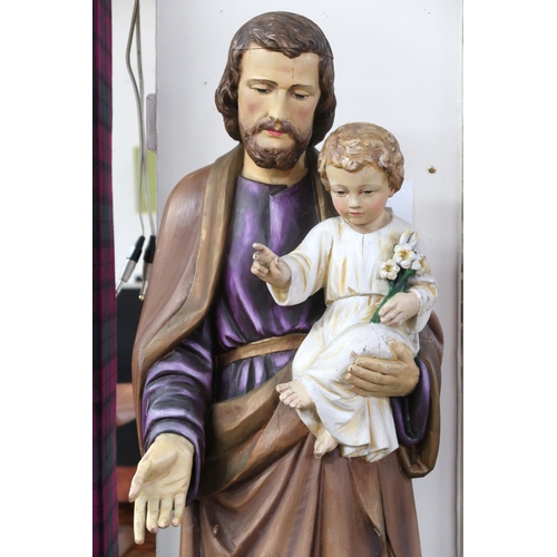 58 - A 20th century painted religious statue depicting St Joseph holding an infant Jesus on octagonal pli... 