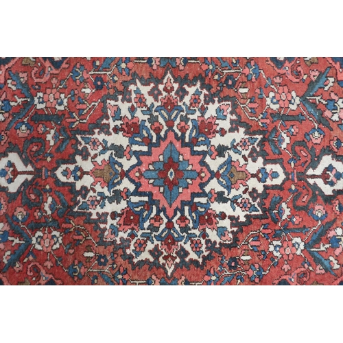 60 - A terracotta ground Tabriz style rug with cream sun burst central medallion, dark blue spandrels and... 