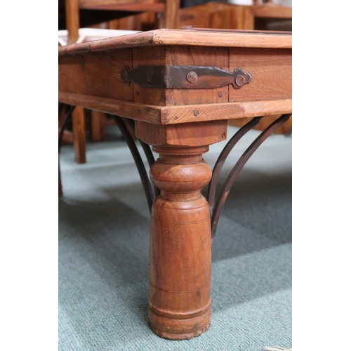 86 - A 20th century mangowood metal bound coffee table on cylindrical supports, 40cm high x 135cm long x ... 