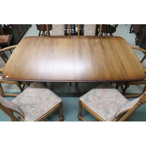 97 - A 20th century Ercol elm and beech extending dining table and six chairs, table on trestle supports ... 