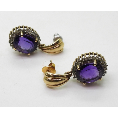 711 - A pair of 9ct gold amethyst and clear gem set earrings, weight 6.1gms